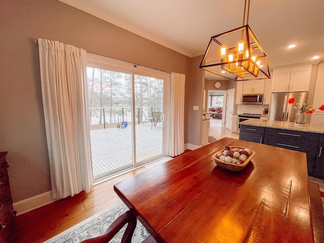 228 Heron Shrs, Mccormick, SC 29835 - dining room featuring baseboards, a notable chandelier, ornamental molding, and light wood-type flooring