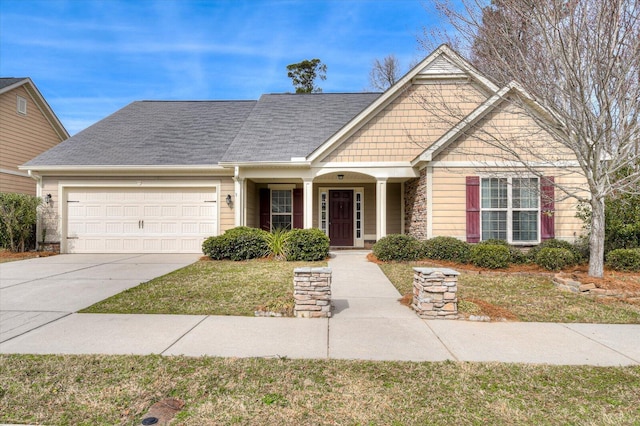 craftsman inspired home with driveway, an attached garage, a front lawn, and a shingled roof