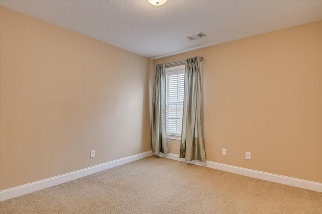 unfurnished room with baseboards, visible vents, a textured ceiling, and carpet flooring