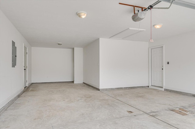 garage featuring a garage door opener, electric panel, and baseboards