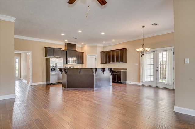 unfurnished living room with baseboards, dark wood-style flooring, visible vents, and crown molding