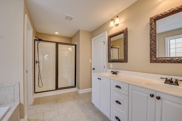 full bathroom featuring visible vents, a sink, a shower stall, and a garden tub