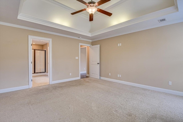 empty room with a raised ceiling, visible vents, and light carpet