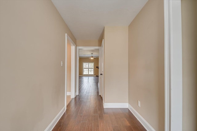 hall featuring wood finished floors and baseboards