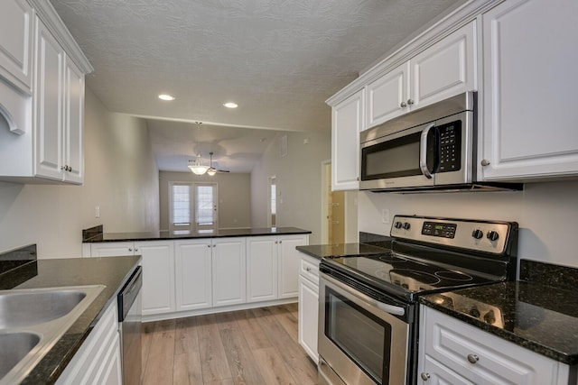 kitchen with sink, appliances with stainless steel finishes, light hardwood / wood-style floors, a textured ceiling, and white cabinets