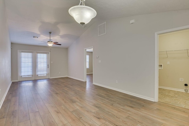 empty room with vaulted ceiling, ceiling fan, and light wood-type flooring