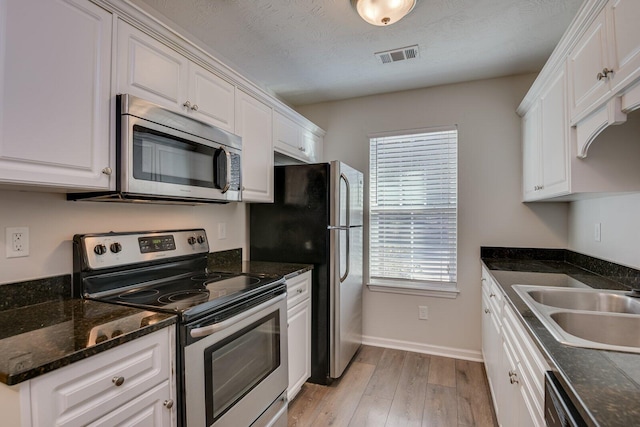 kitchen featuring white cabinetry, stainless steel appliances, and light hardwood / wood-style floors