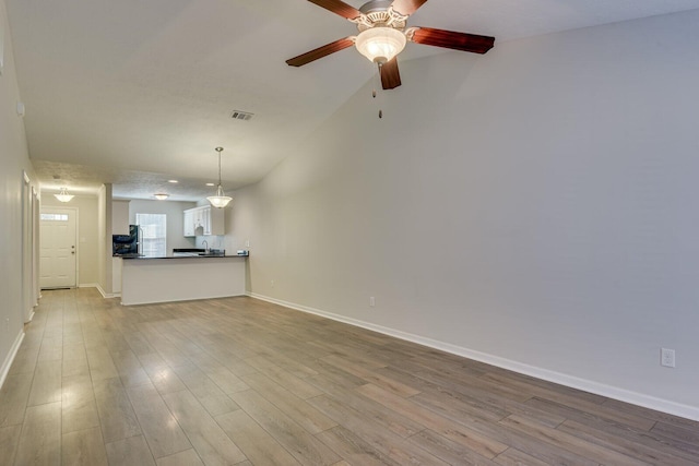 unfurnished living room with ceiling fan and light hardwood / wood-style flooring