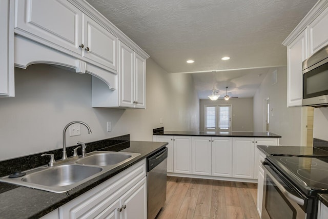 kitchen with sink, light wood-type flooring, appliances with stainless steel finishes, ceiling fan, and white cabinets