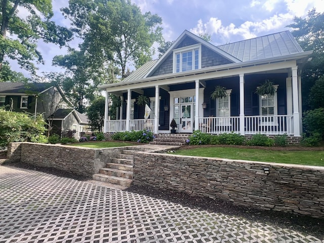 view of front facade featuring a standing seam roof, a porch, and metal roof