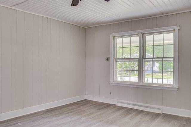 1917 Lazenby Dr, Augusta, GA 30906 - spare room featuring a baseboard radiator, a ceiling fan, light wood finished floors, baseboards, and wooden walls