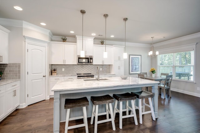 729 Houston Lake Dr, Evans, GA 30809 - kitchen with stainless steel appliances, white cabinetry, a kitchen breakfast bar, tasteful backsplash, and ornamental molding