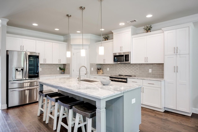 729 Houston Lake Dr, Evans, GA 30809 - kitchen with appliances with stainless steel finishes, white cabinetry, dark wood-style flooring, a kitchen island with sink, and hanging light fixtures