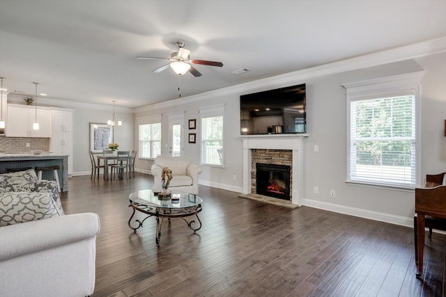 729 Houston Lake Dr, Evans, GA 30809 - living room with a ceiling fan, a stone fireplace, ornamental molding, dark wood-type flooring, and a chandelier