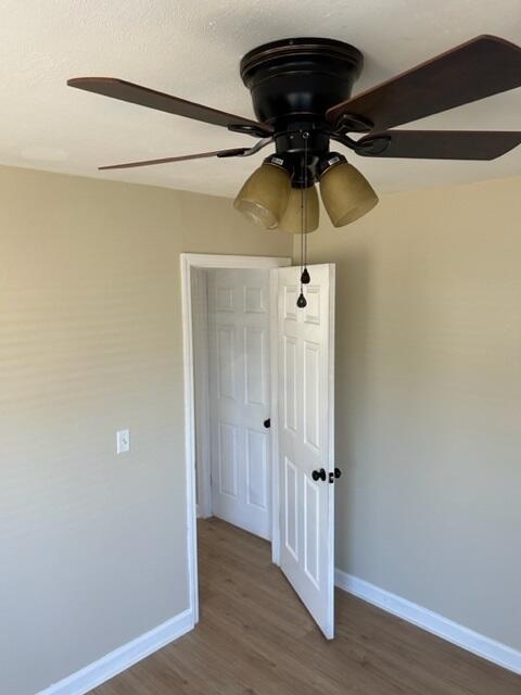 empty room with hardwood / wood-style floors and ceiling fan