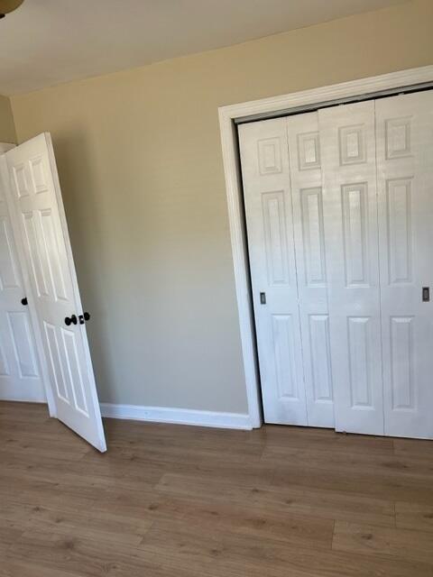 unfurnished bedroom with light hardwood / wood-style floors and a closet