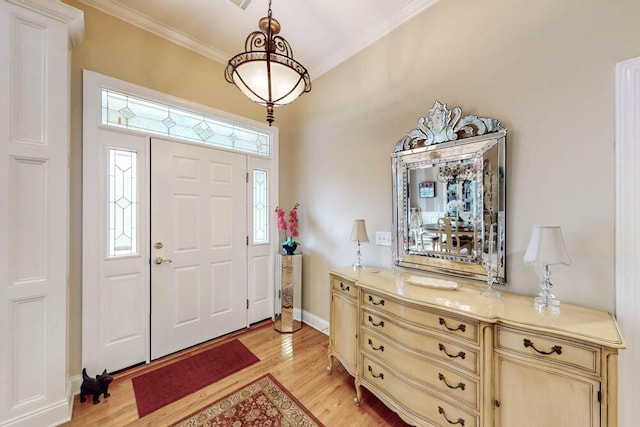 entryway featuring ornamental molding, light wood-type flooring, and baseboards