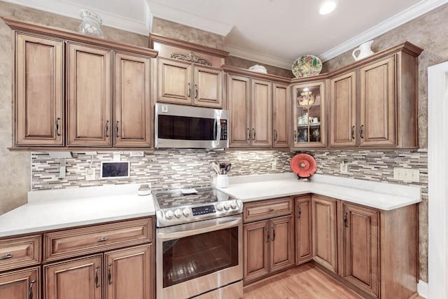 kitchen with appliances with stainless steel finishes, brown cabinetry, crown molding, and decorative backsplash