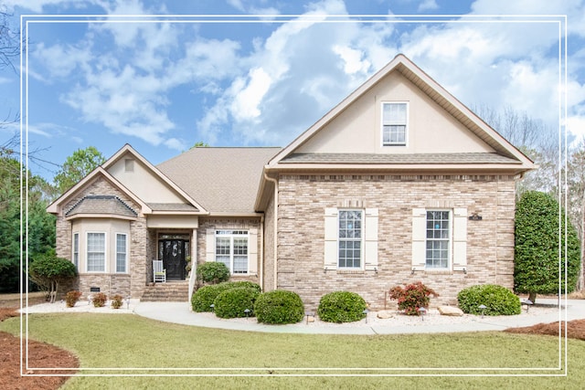 view of front of house with a shingled roof, a front yard, crawl space, and brick siding