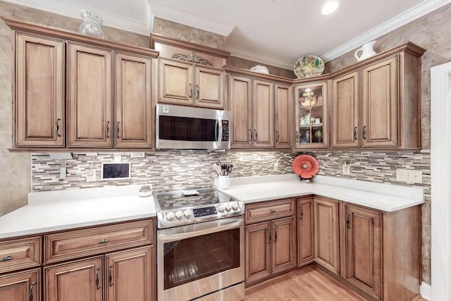 kitchen with stainless steel appliances, brown cabinetry, crown molding, and backsplash