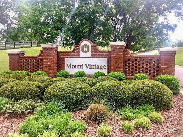 community / neighborhood sign featuring fence