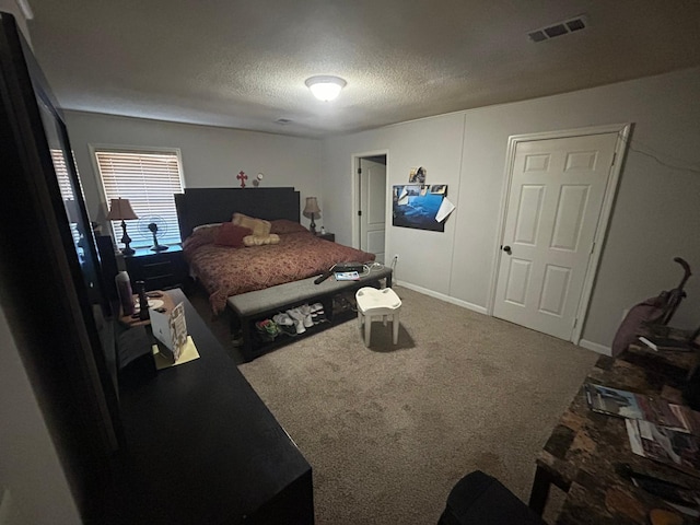 carpeted bedroom with baseboards, a textured ceiling, and visible vents