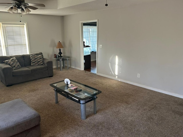 living area with baseboards, carpet, and a ceiling fan