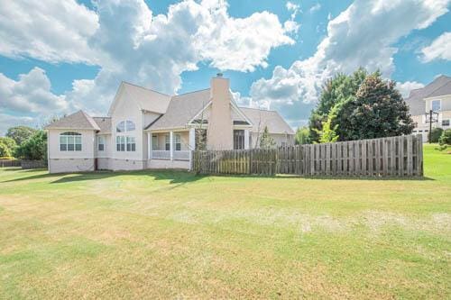 rear view of property with a lawn