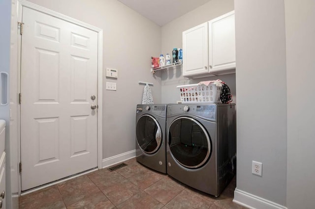 clothes washing area with cabinets and separate washer and dryer