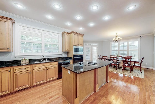 kitchen with sink, an inviting chandelier, light hardwood / wood-style floors, a kitchen island, and black appliances