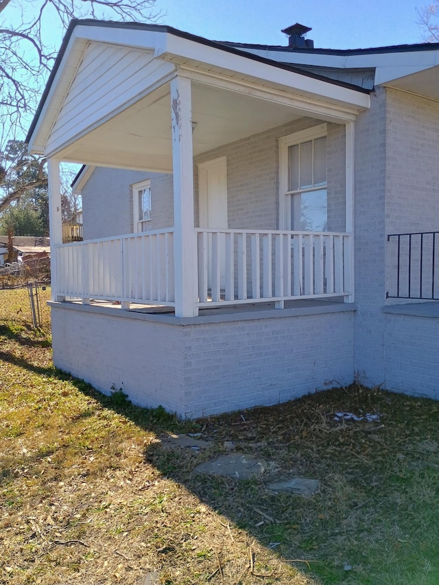 view of home's exterior with brick siding and a porch