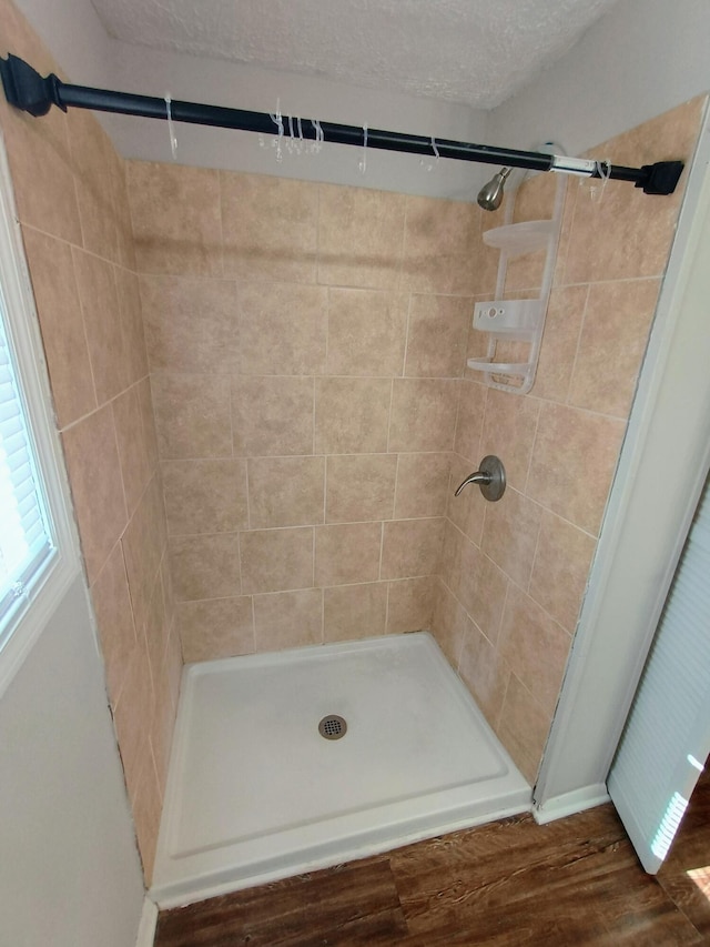 bathroom with a textured ceiling and a shower stall