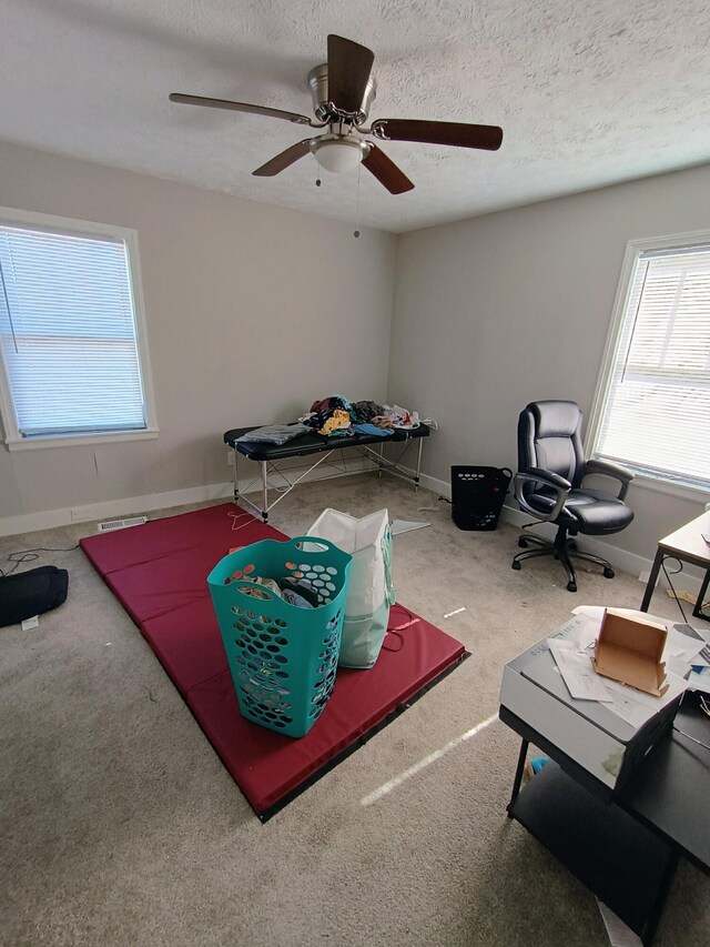 playroom featuring baseboards, a textured ceiling, carpet, and ceiling fan