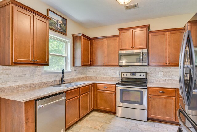 132 Running Creek Dr, North Augusta, SC 29860 - kitchen featuring appliances with stainless steel finishes, a sink, brown cabinets, and light countertops