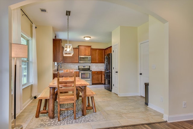 132 Running Creek Dr, North Augusta, SC 29860 - kitchen featuring appliances with stainless steel finishes, light countertops, plenty of natural light, and brown cabinetry