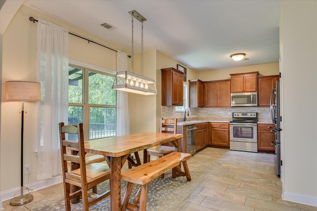 132 Running Creek Dr, North Augusta, SC 29860 - kitchen with appliances with stainless steel finishes, brown cabinets, decorative backsplash, and light countertops