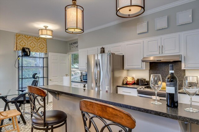 kitchen with white cabinets, stainless steel fridge, and a breakfast bar