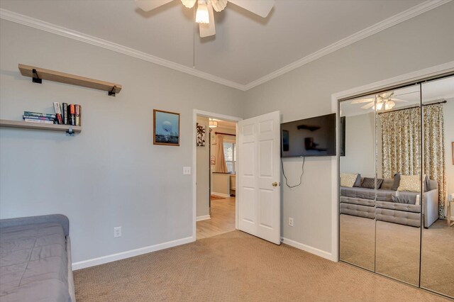 bedroom featuring carpet, a closet, ceiling fan, and crown molding