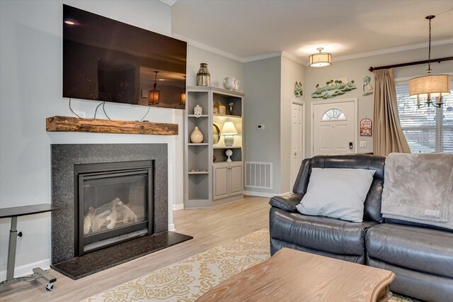 living room with light wood-type flooring and ornamental molding