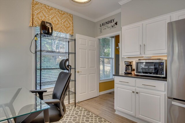 office space featuring light wood-type flooring, ornamental molding, and a wealth of natural light