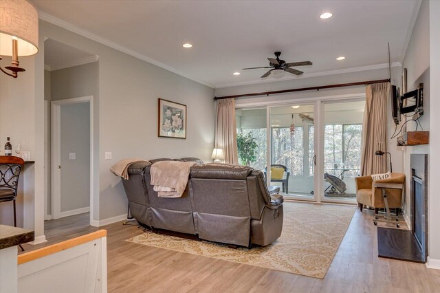 living room with ceiling fan, hardwood / wood-style floors, and ornamental molding