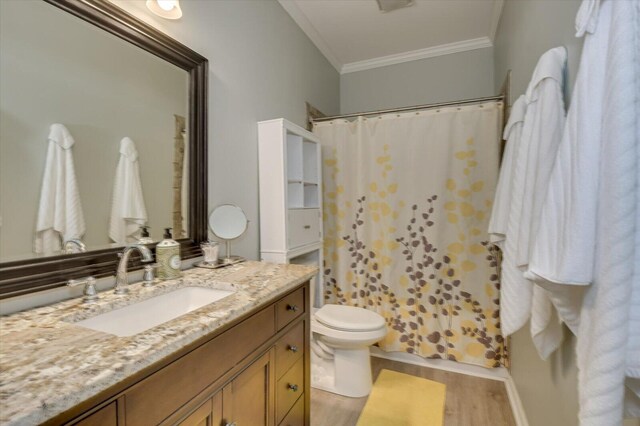 bathroom featuring hardwood / wood-style floors, vanity, toilet, and crown molding