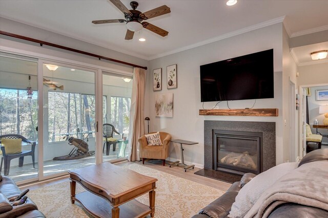 living room with light wood-type flooring, ceiling fan, and crown molding