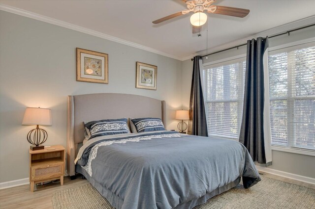 bedroom featuring ceiling fan, crown molding, and light hardwood / wood-style flooring