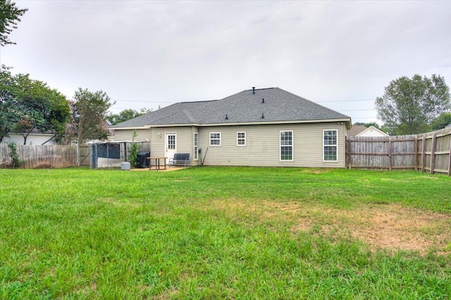 rear view of house featuring a yard