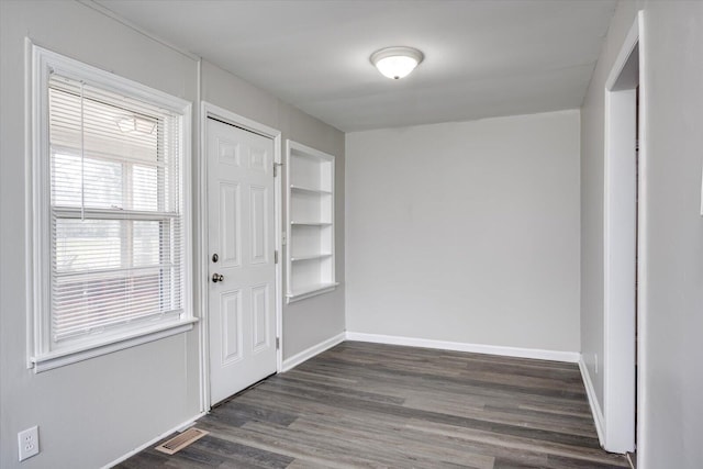 entrance foyer with baseboards, visible vents, and dark wood-style flooring