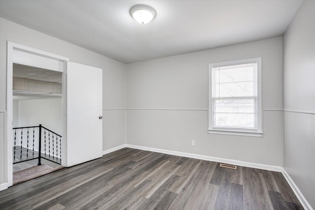 unfurnished bedroom with wood finished floors, visible vents, a closet, and baseboards