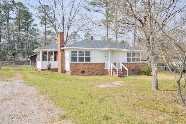 view of front of property with fence, a sunroom, a chimney, a front lawn, and crawl space