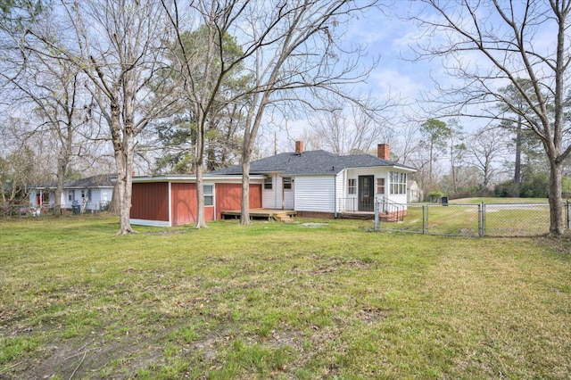 rear view of house featuring a gate, fence, a chimney, a deck, and a lawn