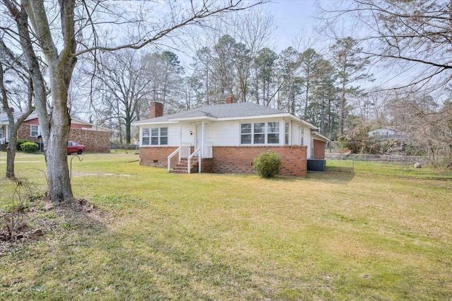 view of front facade featuring fence, a front yard, crawl space, brick siding, and a chimney